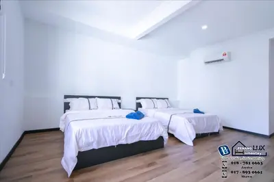two beds in a room with white walls and wood floors at 20BR SwimmingPool Villa Golf View Snooker BBQ in Bayan Lepas