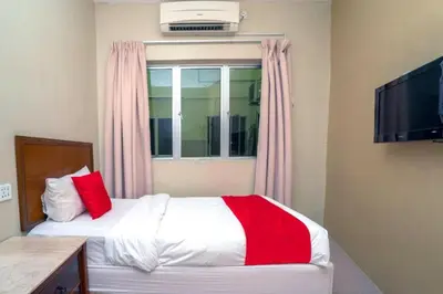 a bedroom with a bed with red pillows and a window at Hotel The Island in Pangkor