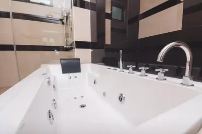 a bathroom with a white sink and a faucet at Luxury 3-sty semi-D 5BR 5Bath@Batu Ferringhi 15ppl in Batu Ferringhi