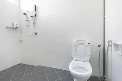 a white bathroom with a toilet and a shower at Penang Balik Pulau Swimming Pool BBQ KTV Homestay in Balik Pulau