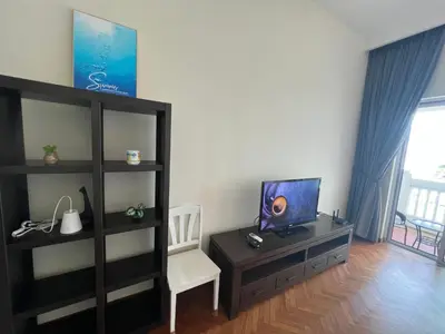 a living room with a tv and a book shelf at 2Beds Seaview Straits Quay comes with Carpark and Hothub in Bagan Jermal