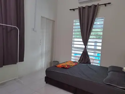 a bedroom with a bed and a large window at Homestay Mohamad & Delisha Tapah -Pool in Tapah