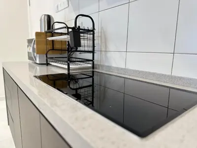 a kitchen counter with a black wire rack on it at 13A5TheSun#BayanLepas#QueensbayMall#CozyHomestay in Bayan Lepas