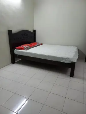 a bed in a room with a white tile floor at AB Tambun Homestay in Ipoh