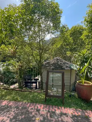 a sign in the grass next to a building at Tingkat Valley in Ipoh