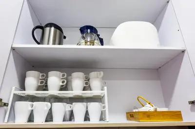 a shelf with dishes and cups in a kitchen at HyperTribe -Pangkor Holiday Home in Kampong Sungai Udang
