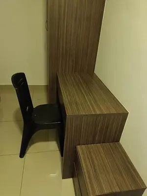 a black chair sitting next to two wooden shelves at Cold house in Cameron Highlands