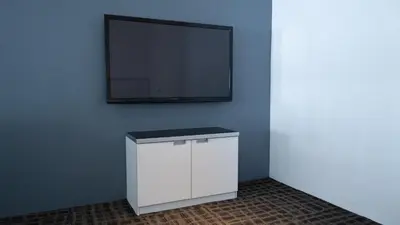a white cabinet with a flat screen tv on a wall at Beverly Hotel in Taiping