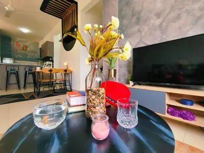 a vase with flowers on a table in a living room at Desig Classic Falim by irainbow in Ipoh