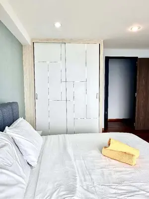 a white bed with a yellow towel on it at SUNRISE GURNEY FULLSEAVIEW LUXURY 2ROOM SUITE 8PAX in Kampong Makam