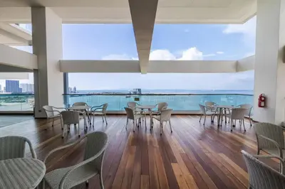 a dining room with tables and chairs and a large window at SUNRISE GURNEY FULLSEAVIEW LUXURY 2ROOM SUITE 8PAX in Kampong Makam