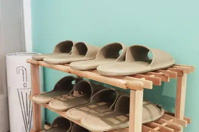 a wooden shelf with pairs of shoes on it at Emerald Avenue Cozy 3R3B Apartment 716 in Brinchang
