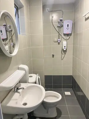 a bathroom with a sink and a toilet and a mirror at Emerald Avenue Cozy 3R3B Apartment 716 in Brinchang