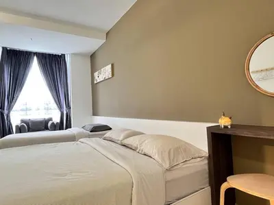 a bedroom with two beds and a mirror at Emerald Avenue Cozy 3R3B Apartment 715 in Brinchang