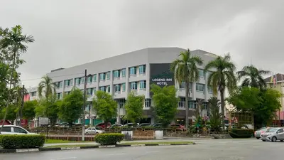 a large building with cars parked in a parking lot at Legend Inn Taiping in Taiping