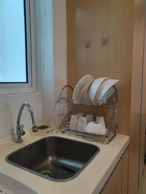 a kitchen sink with dishes in a basket over it at Southbay Seaview Condo A10 #10minQueensbay #15minSPICE in Bayan Lepas
