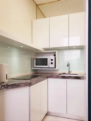 a kitchen with white cabinets and a microwave at Charming Studio 1BR 1LR Condo Georgetown \u9b45\u529b\u4e00\u5ba4\u4e00\u5385\u5957\u623f in George Town