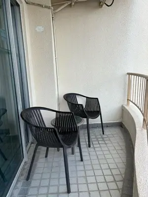 two black chairs and a table on a balcony at Rainbow deluxe seaview in Tanjung Bungah
