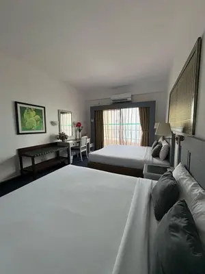 a hotel room with two beds and a desk at Seaview Deluxe Rainbow Paradise Tg Bungah 6pax in Tanjung Bungah