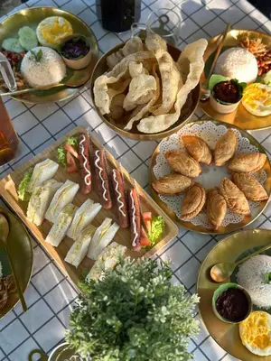 a table topped with plates of food and bread at DeAsmarra Homestay in Tanjung Piandang
