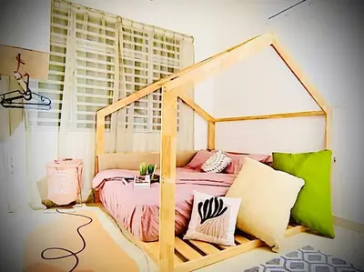 a bed with a wooden frame in a room at Muji Home Falim in Ipoh