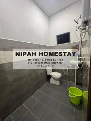 a bathroom with a toilet and a sign that reads nirvana homasy at Nipah Homestay Parit Buntar in Parit Buntar