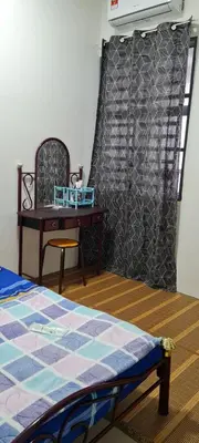 a bedroom with a bed and a table and a chair at D'HutHomestay Puncak Iskandar in Seri Iskandar