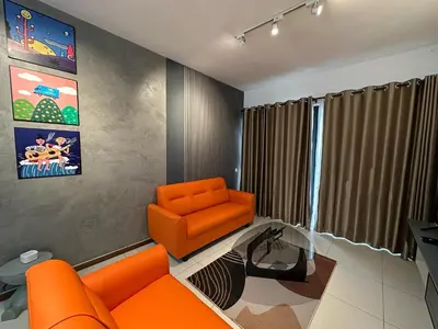 a living room with an orange chair and a couch at NEW 4Queen Bed 3 Room 2CP near Gurney with tvbox and KTV Set in Tanjong Tokong