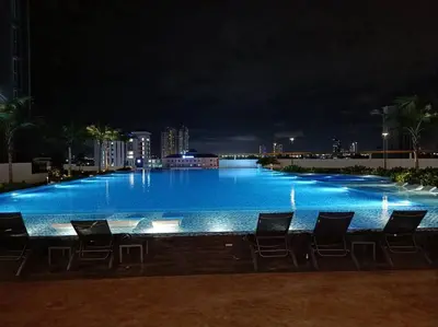 a large swimming pool with chairs at night at Paradise Home- 10Pax/4CarPark- Pg Bridge/KPJ Hosp in Bukit Mertajam