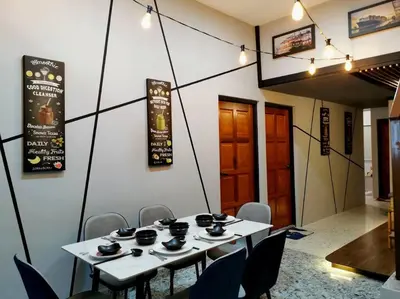 a dining room with two tables and chairs with cups on them at English comfort house in ipoh by SuccessWisdom\u5ea6\u5047\u667a\u5bcc in Ipoh