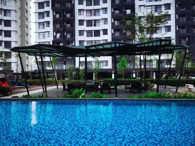 a swimming pool with tables and umbrellas in a building at Ipoh Cozy Modern Suite 6-7pax @ Adson's Home in Ipoh