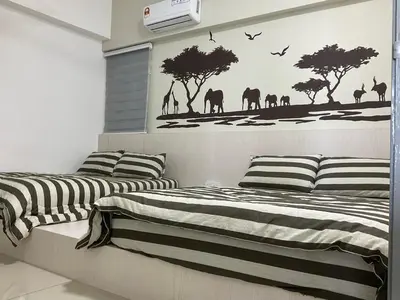 two beds with black and white sheets in a bedroom at Sweet Homestay The Venus Sitiawan \u6e29\u99a8\u6c11\u5bbf in Sitiawan