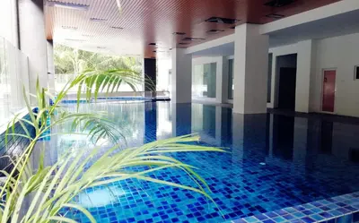 a swimming pool with blue tiles in a building at Sweet Homestay The Venus Sitiawan \u6e29\u99a8\u6c11\u5bbf in Sitiawan