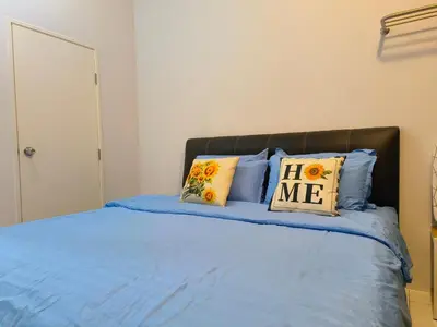 a bedroom with a bed with blue sheets and pillows at New The Sun Homestay at Sg Nibong nearby Queensbay or PISA or FTZ Bayan Lepas HENG in Bayan Lepas