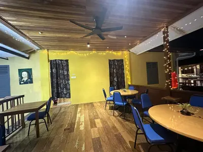 a restaurant with tables and chairs and a ceiling fan at The Century Aigoh Hotel in George Town