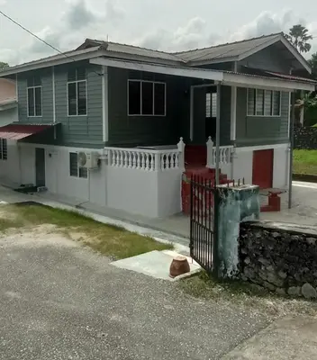 a house with a white fence in front of it at Kurnia Homestay in Slim River