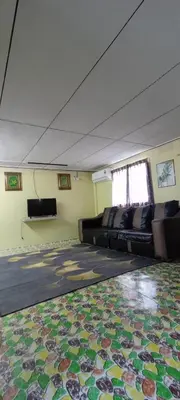 an empty room with couches and a rug on the floor at Kurnia Homestay in Slim River