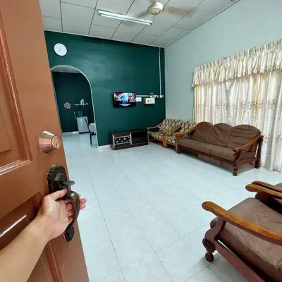 a person opening a door to a living room at Adam Homestay in Ipoh