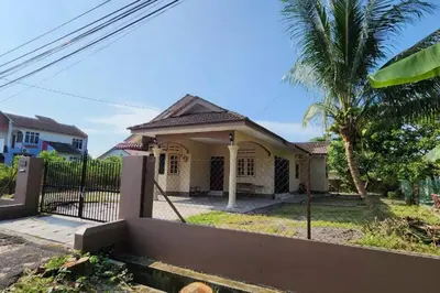 a house with a fence and a palm tree at Adam Homestay in Ipoh