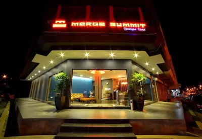 a building with a neon sign on top of it at Merge Summit by Secoms in Teluk Intan