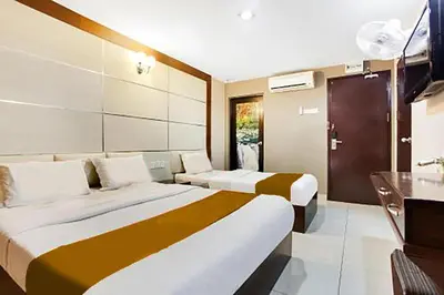 a hotel room with two beds and a television at Sejati Hotel in Sitiawan