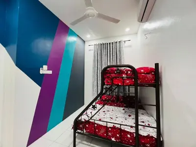 a red bunk bed in a room with a colorful wall at SRS WIN Homestay in Sungai Petani
