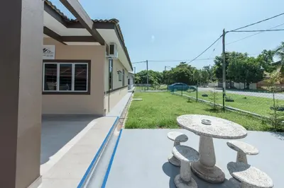 a patio with a stone table outside of a building at Zai Ham Homestay in Pusing