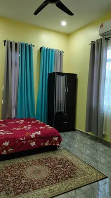 a bedroom with a bed and blue curtains at Rizki Homestay Nibong Tebal in Nibung Tebal