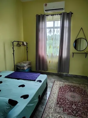 a bedroom with two beds and a window at Rizki Homestay Nibong Tebal in Nibung Tebal