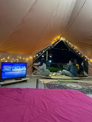 a group of people sitting in a tent with a tv at The Backyard Glamping Cameron Highlands in Tanah Rata