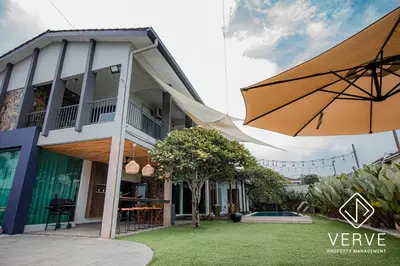 a building with an umbrella next to a yard at Ipoh 188 Private Pool Mansion by Verve 30 pax EECH119 in Ipoh