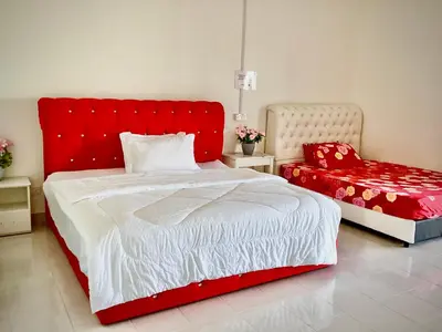 a bedroom with a red bed and a red chair at Homestay Kampar Putra in Kampar