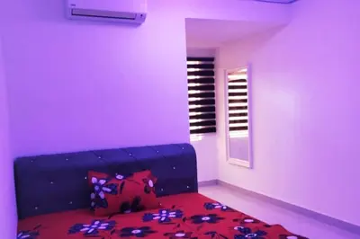 a purple room with a couch and a window at Homestay Kampar Putra in Kampar