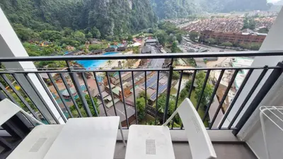 a balcony with white chairs and a view of a city at H&W Sunway Onsen Suites Services Tambun Ipoh S-15-12 in Ipoh